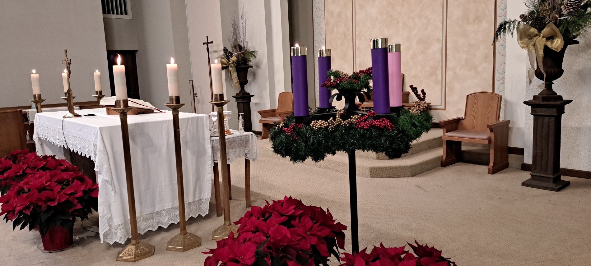 Picture of altar showing 2 candles of advent candle wreath lit