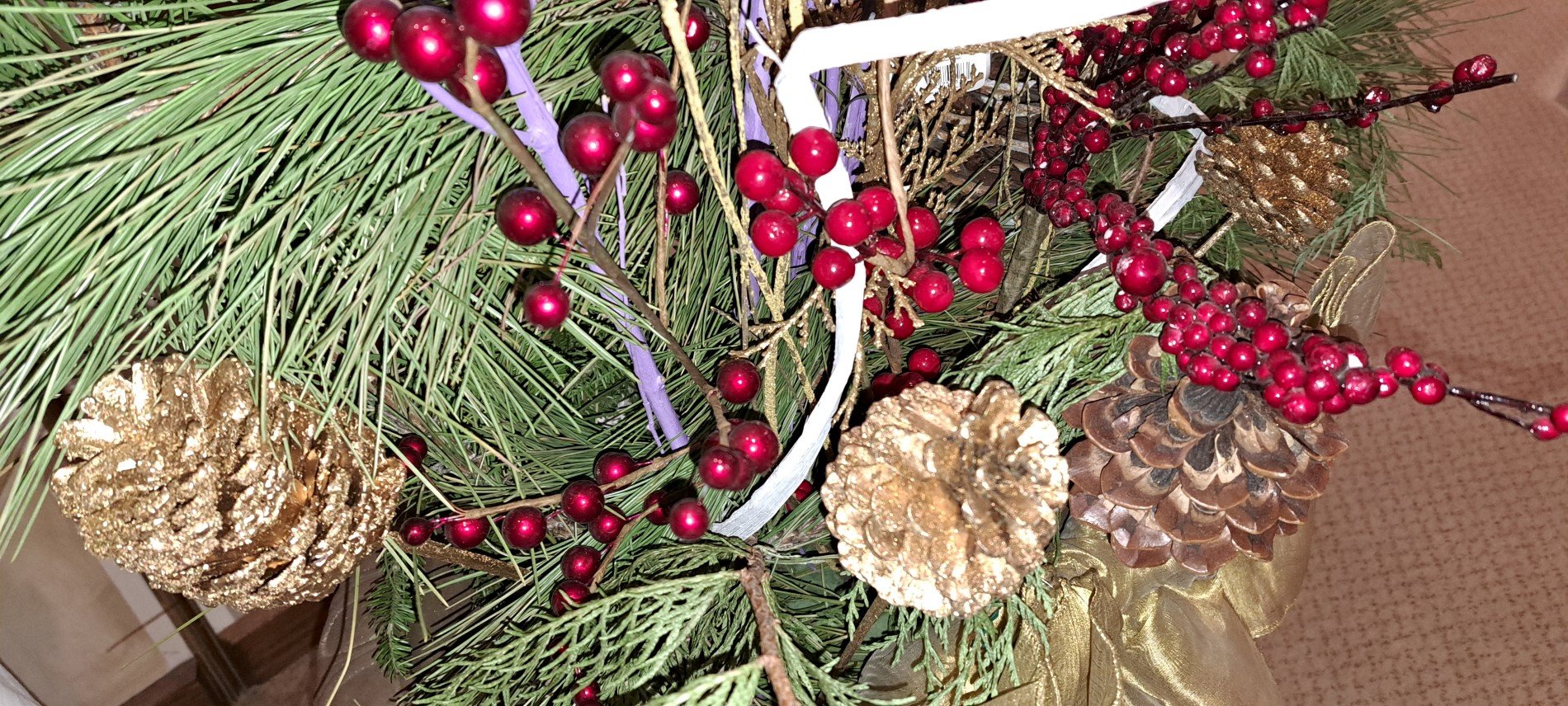 Picture of planter in front of the tabernacle with gold satin bough, tree branches, gold sticks, picks with red berries
