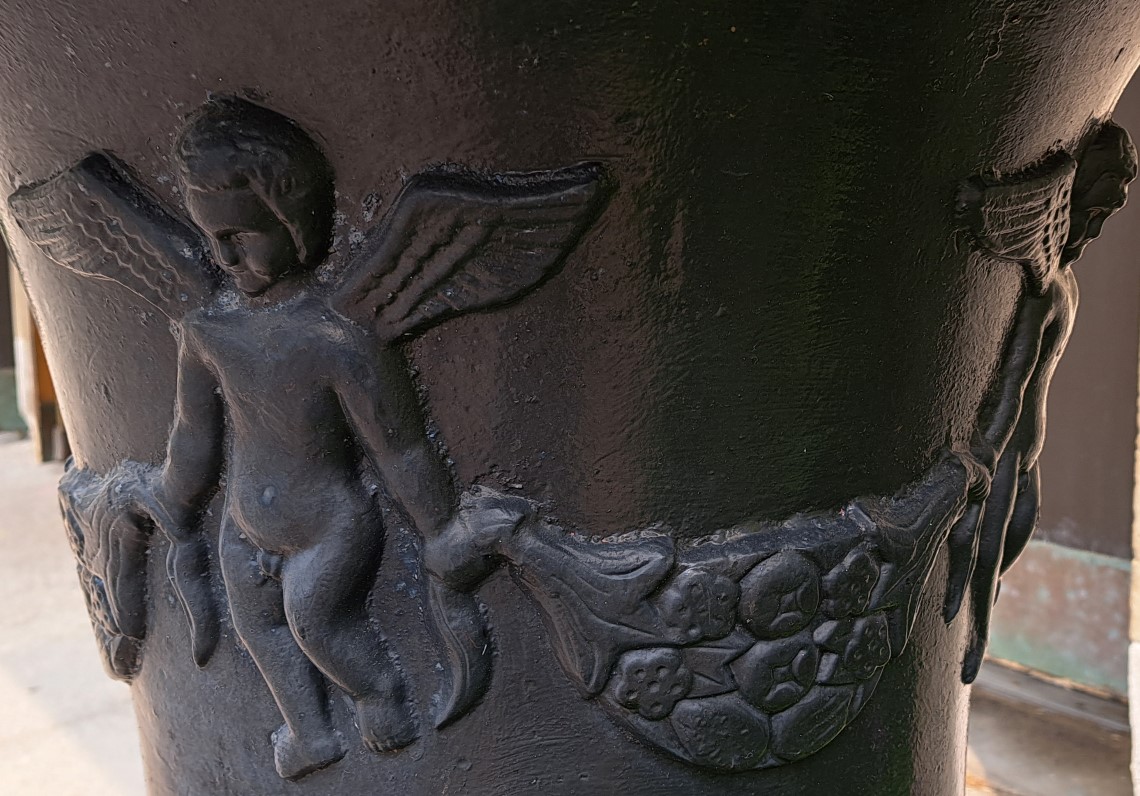 Picture of one of the angels on one of the black planters in front of the church