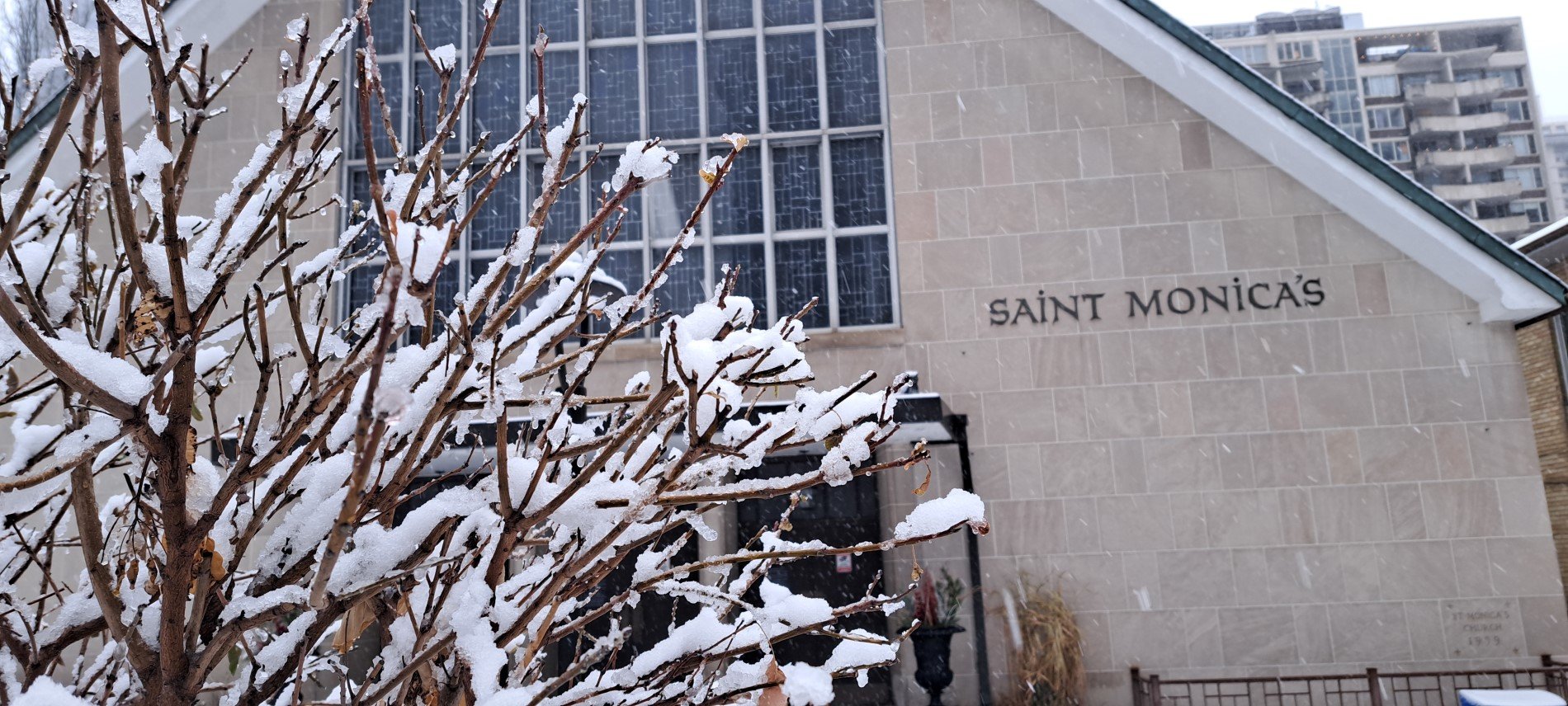 Front of church with snow on branches on foreground
