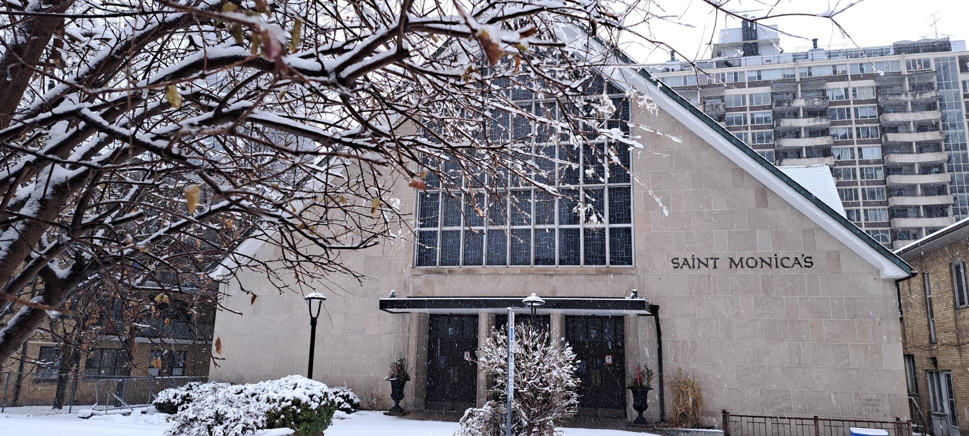 Front of church with snow on branches on foreground