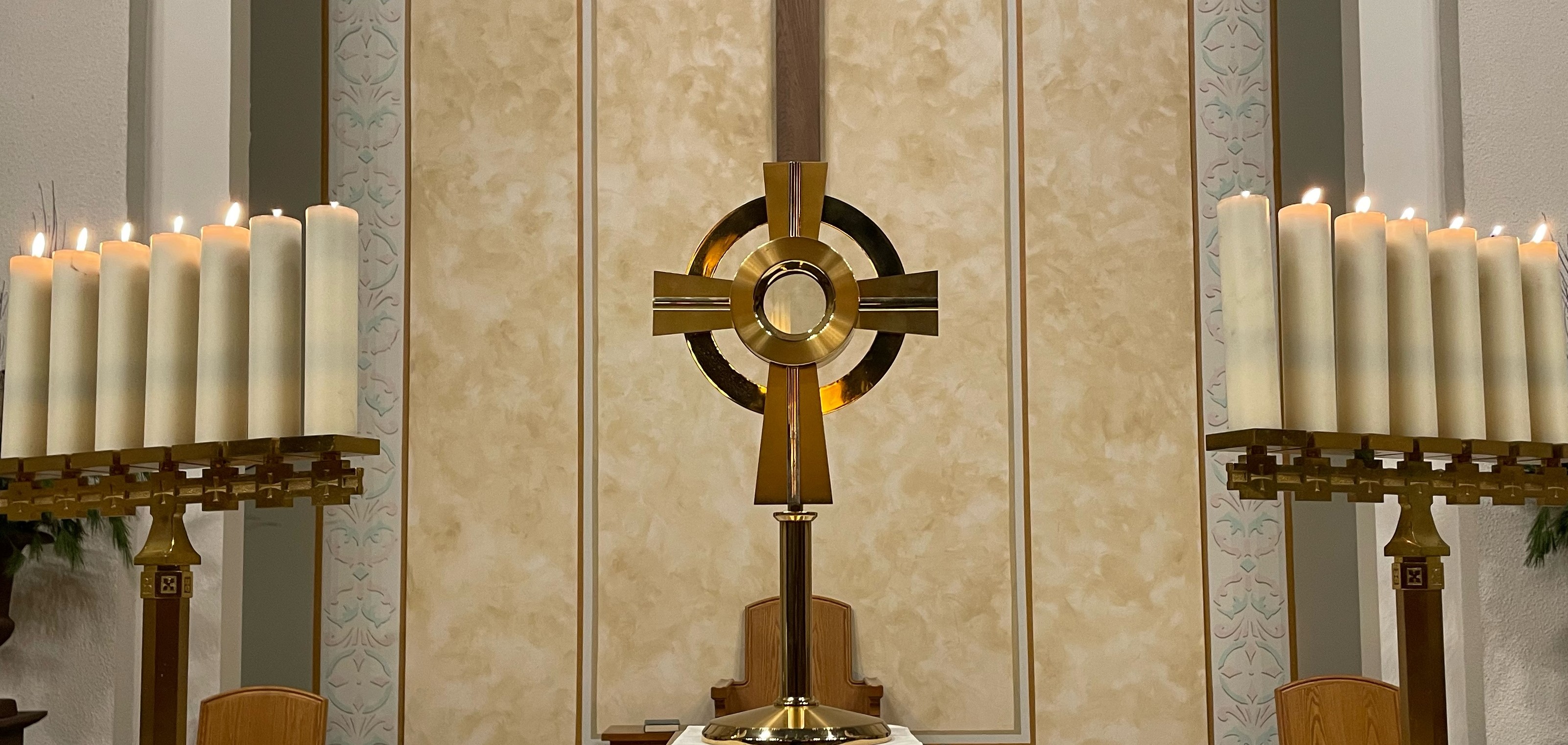 Picture of monstrance with Eucharist flanked by candelabras on both sides