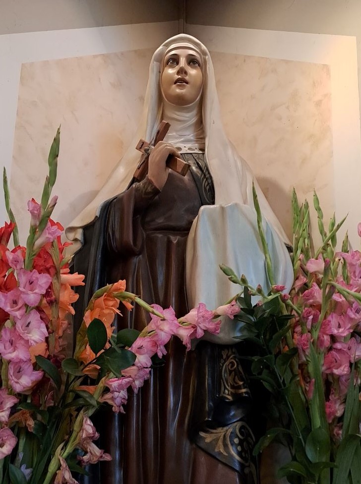 Picture of St. Monica's statue with flowers