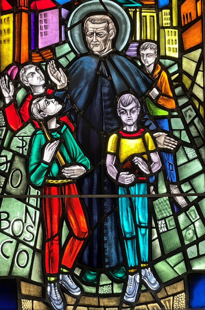 Stained glass window in sacristy showing image of St. John Bosco